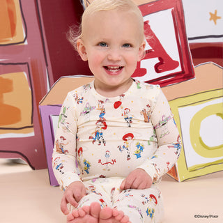 Magnetic Me x Disney L/S Modal Pajama Set - Toy Story Woody & Friends
Child wearing a patterned outfit sitting in front of colorful letter blocks