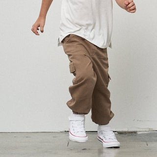 Little Bipsy Cotton Twill Cargo Jogger - Mushroom
Person wearing brown cargo pants and white high-top sneakers against a plain background
