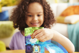 Magna-Tiles Hamster Ball™ 13-Piece Set
Child playing with a toy water table in a cozy living room.