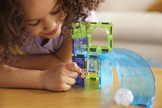 Magna-Tiles Hamster Ball™ 13-Piece Set
Child playing with a colorful marble run toy on a wooden surface