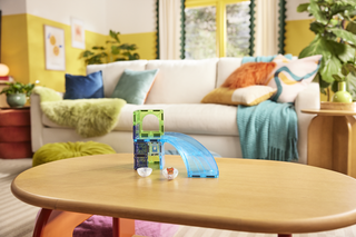 Magna-Tiles Hamster Ball™ 13-Piece Set
Children's toy slide on a wooden table with a colorful living room in the background