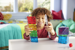 Magna-Tiles Rail Racers™ 33-Piece Set
Child playing with colorful building blocks in a bright room