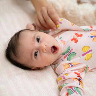 Magnetic Me Modal Footie - Fruit Flies
Baby wearing a colorful onesie lying on a white blanket