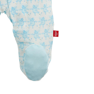 A close-up of a baby footed sleeper or bootie in white fabric with a light blue all-Magnetic Me Modal Magnetic Footie - Trunkettes Blue
over print of dancing figures and a solid light blue padded foot area. A small red fabric tag with white lettering is visible on the side.