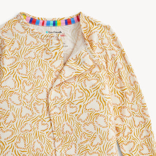 Magnetic Me Modal Magnetic Footie - Wild Side
A close-up of a long-sleeve button-front top with an allover abstract orange and yellow pattern on a cream base. The inner collar shows a colorful striped lining and a visible 'Eco-Friendly G100' label.