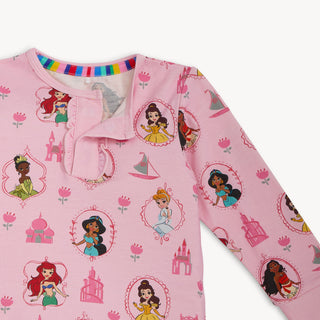 Magnetic Me x Disney Princess Modal Ruffle L/S Pajama Set - Princess Royal Radiance
Pink long-sleeve shirt with Disney princesses and castles on a white background