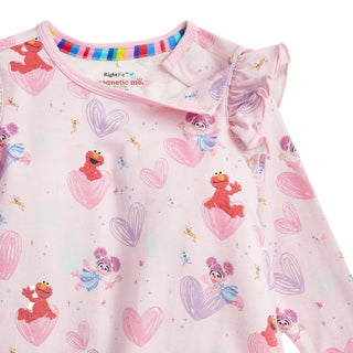 Magnetic Me x Sesame Street RightFit™ Magnetic Nightgown - Elmo & Abby
A close-up of a children's long-sleeve top in light pink with an all-over Sesame Street print featuring Elmo, Abby, and hearts, on a white background.