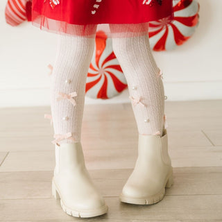 Sweet Wink Bedazzled Coquette Tights - Pink
White rain boots worn with red and white striped socks on a light wooden floor.