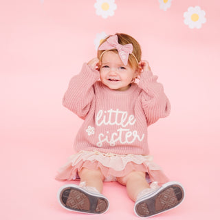 Sweet Wink Little Sister Knit Sweater
Baby wearing a pink sweater with 'little sister' text on a pink background with daisies.