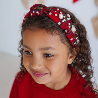 Sweet Wink Christmas tartan pearl headband worn by a model, featuring festive red and green plaid fabric with pearl accents.