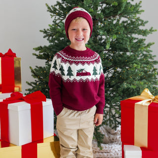 Model wearing Sweet Wink Christmas Truck Fair Isle Sweater in khaki, paired with joggers and a Christmas tree fair isle beanie.