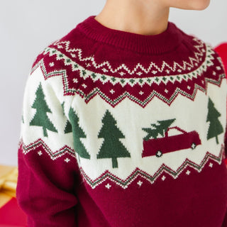 Model wearing Sweet Wink Christmas Truck Fair Isle Sweater in khaki, paired with joggers and Christmas tree fair isle beanie.