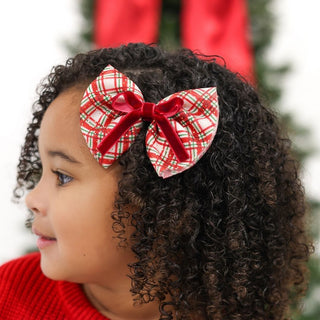 Sweet Wink Christmas Plaid Layered Bow Clip
Child with curly hair wearing a red and green plaid bow against a blurred Christmas tree background