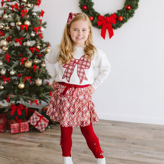 Sweet Wink Christmas Plaid Bow Patch Sweatshirt - Natural
Young girl in festive outfit with Christmas tree and wreath in background