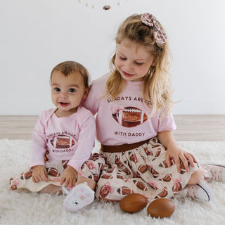 Sweet Wink Football With Daddy Short Sleeve T-Shirt - Ballet Sweet Wink Football With Daddy Long Sleeve Bodysuit - Ballet Two children wearing matching pink outfits with text and graphics on a white background