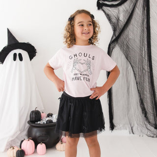 Sweet Wink Ghouls Just Wanna Have Fun Halloween Short Sleeve T-Shirt
A young girl with curly hair stands in a Halloween-themed room wearing a light pink graphic t-shirt that reads 'Ghouls Just Wanna Have Fun' and a black tulle skirt. She is posed in front of a white ghost decoration, black netting, and pumpkins.