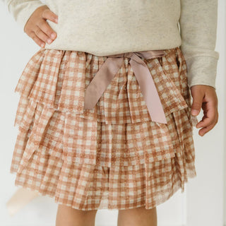 Sweet Wink Gingham Printed Tulle Tiered Tutu
Person wearing a checkered skirt with a pink ribbon on a white background