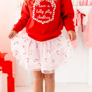 Model wearing Sweet Wink Holly Jolly Christmas sequin bow patch sweatshirt with candy cane accents and festive holiday design.