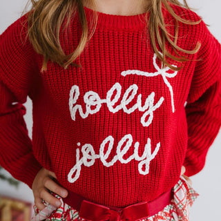 Sweet Wink Holly Jolly Bow Christmas Knit Sweater - Kids
Red sweater with 'holly jolly' text worn by a child, with a blurred background.
