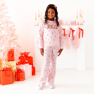 Model wearing Sweet Wink Jolly Pearl Patch Candy Cane sweatshirt and flare leggings Christmas 2-piece set with peppermint glitter and bow details.