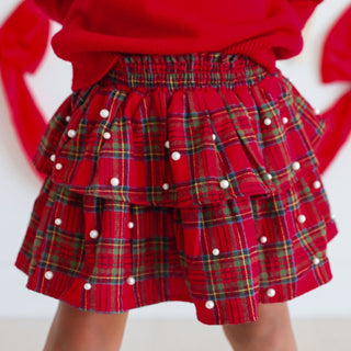 Model wearing Sweet Wink Christmas tartan pearl tutu skirt with festive holiday style and pearl embellishments.