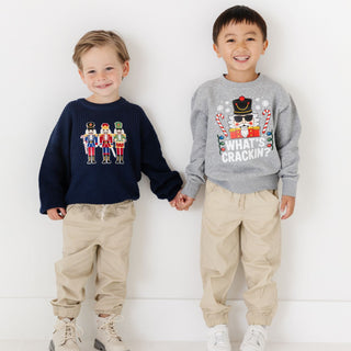 Model wearing a Sweet Wink Nutcracker Patch Christmas Sweater featuring festive nutcracker patch and holiday-themed design.