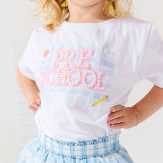 Sweet Wink Preschool Pearl Patch Short Sleeve T-Shirt
Child wearing a white t-shirt with 'PRE SCHOOL' printed on it, standing against a plain background.