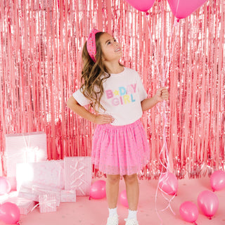 Sweet Wink Raspberry Rhinestone Tutu Skirt
Young girl in a 'Baby Girl' shirt with pink tulle skirt and headband, surrounded by pink balloons and tinsel.