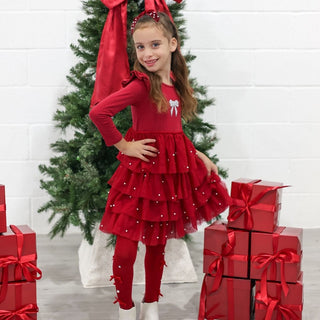 Sweet Wink Bedazzled Coquette Tights - Ruby Red
Sweet Wink Christmas Pearl Long Sleeve Tutu Dress
Young girl in a red dress standing in front of a Christmas tree with presents.