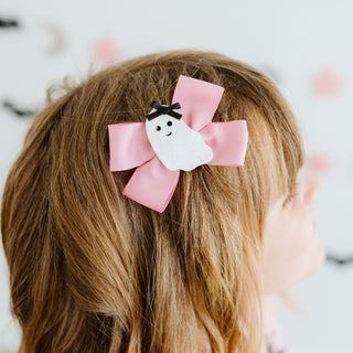 Sweet Wink Sweet Ghost Halloween Grosgrain Bow Clip
A pink ribbon hair bow hair clip with a white ghost charm and black bow, shown clipped to a child's brown hair.