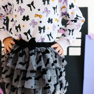 Sweet Wink Flocked Bats Halloween Bow Tiered Tutu 
Child wearing a dress with bow patterns in various colors against a neutral background