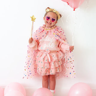 Sweet Wink Birthday Girl Sprinkle Knit Sweater
Child in a pink outfit with a star wand and heart sunglasses, surrounded by pink balloons.