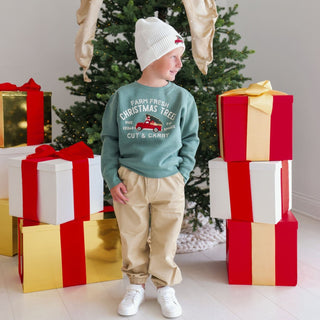 Model wearing Sweet Wink Farm Fresh Christmas Tree patch sweatshirt in khaki with Christmas truck patch and beanie.