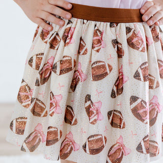 Sweet Wink Football Cutie Tutu Skirt with football and bow pattern worn by a person