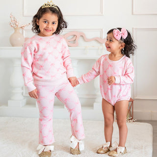 Sweet Wink Bow Trellis Sweatshirt & Flare Legging Set
Two children wearing pink tie-dye outfits standing in a room with decorative elements.