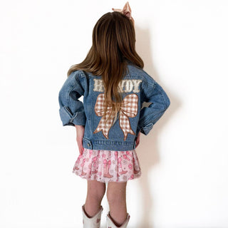 Sweet Wink Howdy Gingham Bow Patch Denim Jacket
Child wearing a denim jacket with a large bow and 'Becoy' text on the back, standing against a white background.