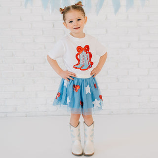 Model wearing Sweet Wink patriotic cowgirl patch short sleeve T-shirt with red glitter bow and tutu, showcasing a festive, stylish look.
