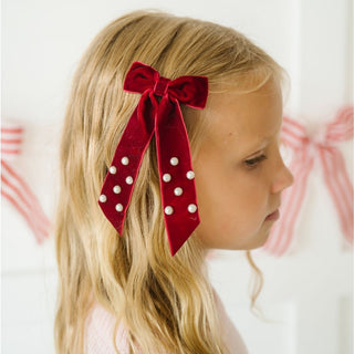 Sweet Wink Ruby Red Velvet Coquette Bow Clip
Young girl with blonde hair wearing a red bow with white polka dots.