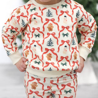 Sweet Wink Christmas Cutie Sweatshirt & Flare Legging Set
Child wearing a Christmas-themed sweater and pants with red bows, gingerbread men, and trees.