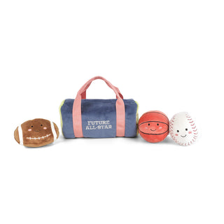Mon Ami Sports Play Bag
A soft toy sports bag set with a navy blue duffel bag labeled 'FUTURE ALL-STAR' in white text, flanked by three plush sports balls: a brown football, an orange basketball, and a white baseball, all with embroidered smiling faces. The bag has pink handles and trim, and the balls have contrasting colors.