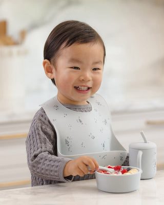 Mushie x Quincy Mae Space feeding set with a plate, bowl, cup, and utensils in a celestial design for babies and toddlers.