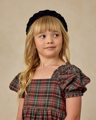 Noralee Louella Dress - Winter Tartan
Young girl wearing a plaid dress and black headband against a beige background