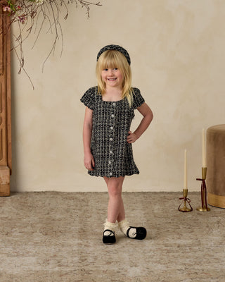 Noralee Gabrielle Dress - Black
Young girl in a black and white dress standing in a room with decorative elements.
