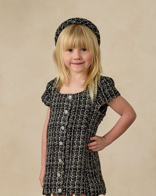 Noralee Padded Headband - Black Tweed
Noralee Gabrielle Dress - Black
Young girl wearing a black and white patterned dress with a headband on a beige background