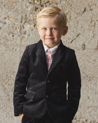 Noralee Sebastian Blazer - Black
Young boy in a dark suit standing against a textured wall.