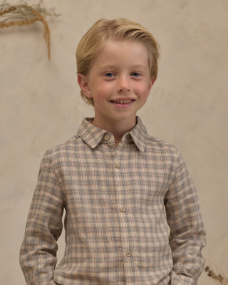 Noralee Harrison Button Down - Fall Plaid
A young blonde boy smiling while wearing a beige and brown plaid long-sleeve button-down shirt, set against a neutral textured beige wall.