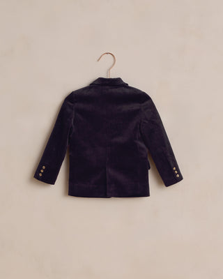 Noralee Sebastian Blazer - Black
Black  velvet blazer on a hanger against a beige background