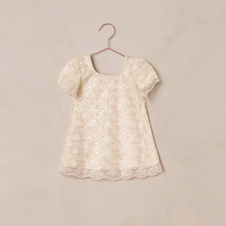 Noralee Daisy Dress - Silver Metallic
White lace dress on a hanger against a beige background
