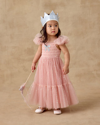 Noralee Clara Dress - Rose
Young girl in a pink dress with ruffles and a silver crown on a beige background