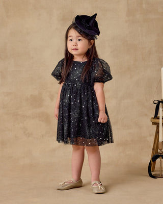 Noralee Luna Dress - Night Sky
Young girl wearing a black star-patterned dress and hat against a beige background